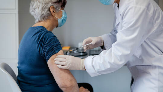 Senior woman being vaccinated against coronavirus