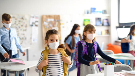 Group of children with face mask back at school after covid-19 quarantine and lockdown.