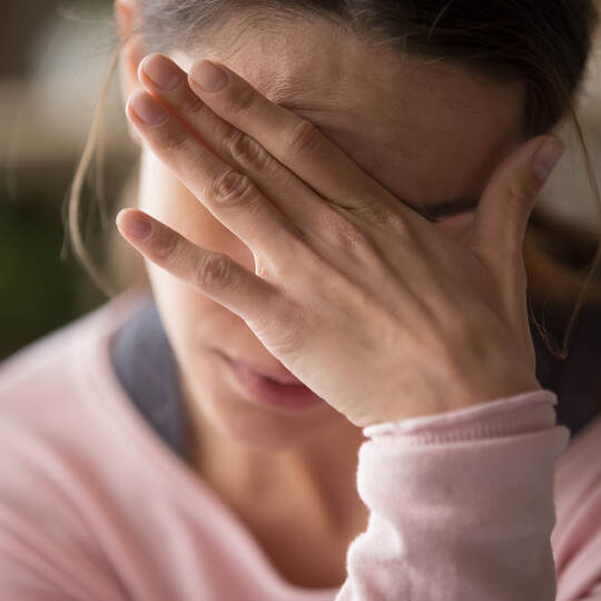 Sad tired woman touching face having headache or depression