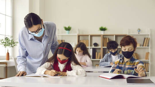 School students and teacher wearing face masks in class to protect from Covid-19