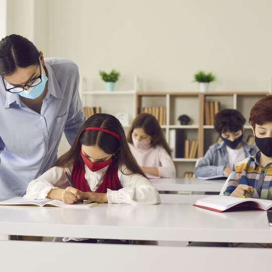 School students and teacher wearing face masks in class to protect from Covid-19