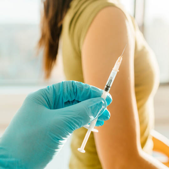 Vaccine against coronavirus at medical clinic banner. Woman being vaccinated with syringe held by healthcare professional worker