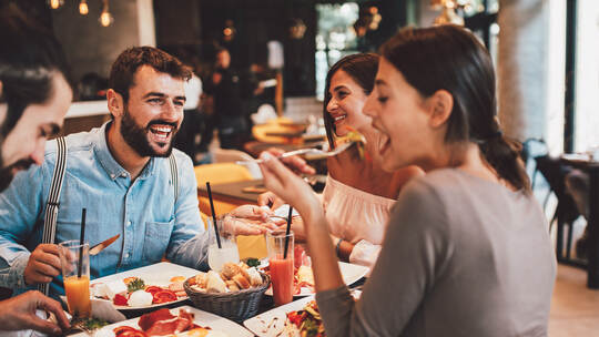 Group of Happy friends having breakfast in the restaurant
