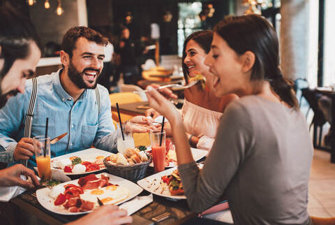 Group of Happy friends having breakfast in the restaurant
