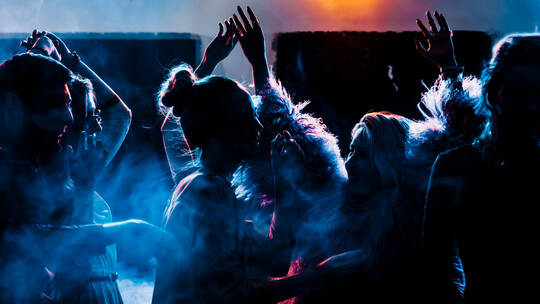 party at a nightclub, young people boys and girls dancing in a smoke