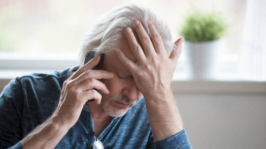 Frustrated mature man feeling upset desperate talking on the pho