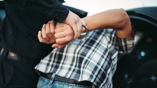 Policeman arrests the car thief on road