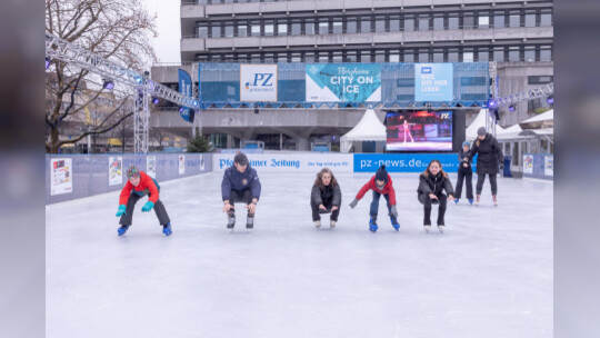 Kinder lernen auf der PZ-Eisbahn Eislaufen