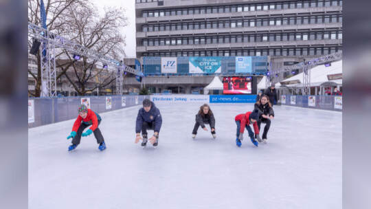 Kinder lernen auf der PZ-Eisbahn Eislaufen