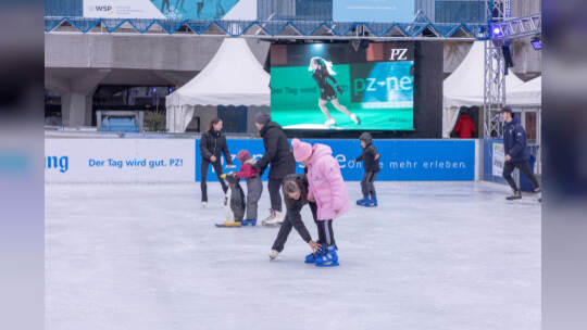 Kinder lernen auf der PZ-Eisbahn Eislaufen