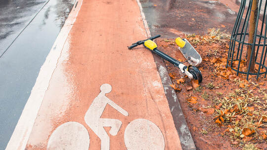 A broken electric scooter on a bicycle path as a result of a collision with a pedestrian or a cyclist