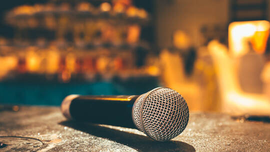 Microphone on the ground and blurred photo of conference hall or seminar room or wedding room background.