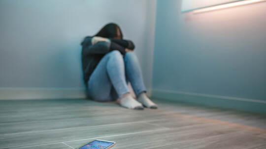 Unrecognizable woman covering her face desperate for cyberbullying