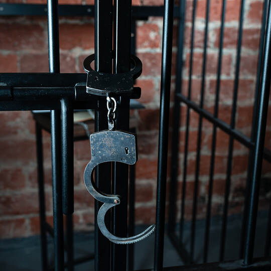 Open handcuffs hang on the cage. Successful release from liability