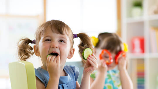 children eating vegetables in kindergarten or at home
