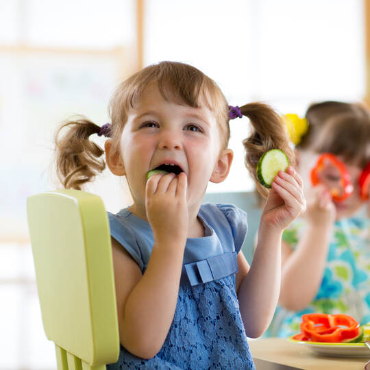 children eating vegetables in kindergarten or at home