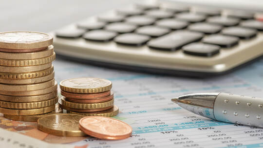 Geld mit Taschenrechner und Kugelschreiber