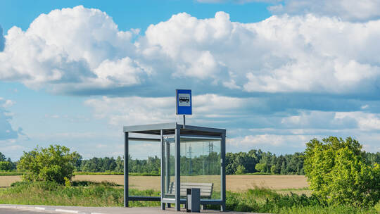 Empty bus stop by the field.