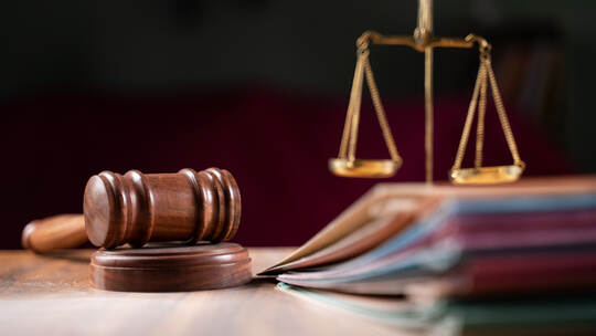 focus on hammer, group of files on judge table covered with dust - concept of pending old cases or work at judicial court