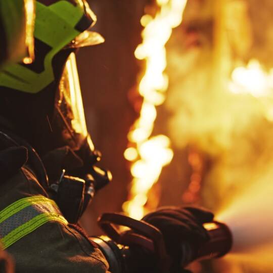 Fireman extinguish fire with the hose. Burning house fire drill