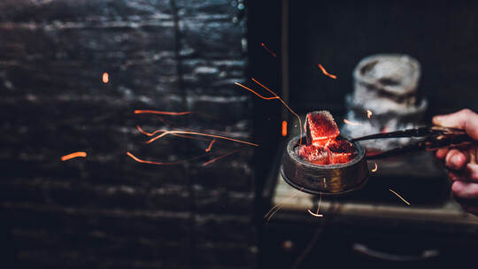 Shisha hookah with red hot coals. Sparks from breathe. Modern hookah with coconut charcoal for relax and shisha smoke. Hookah an