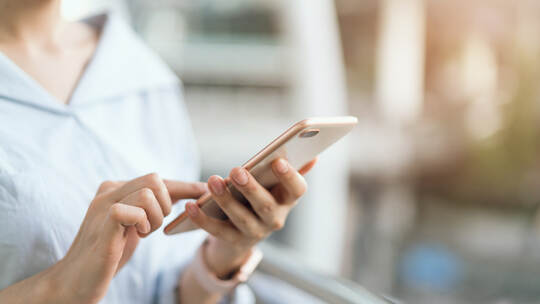 woman using smartphone on staircase in public areas, During leisure time. The concept of using the phone is essential in everyda