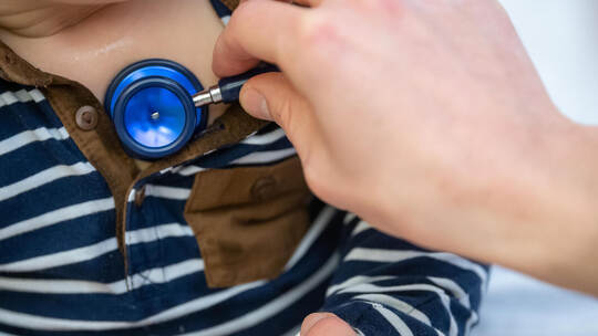 Kinderarzt untersucht Kind