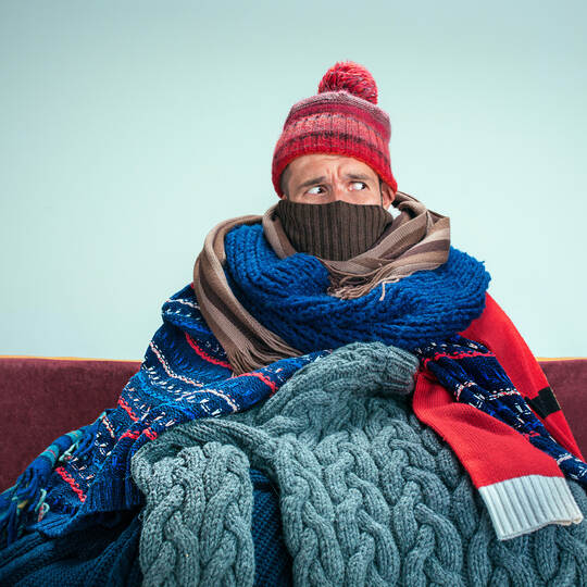 Bearded Man with Flue Sitting on Sofa at Home. Healthcare Concepts.