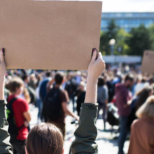 Rear view of people with placards and posters on global strike for climate change.