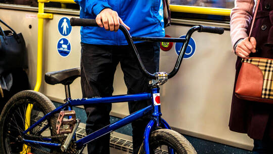 man stanidng in the public transport bus with the bicycle
