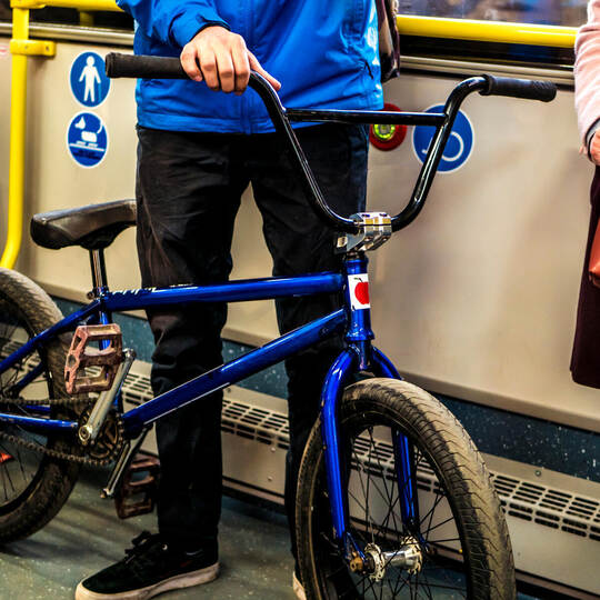 man stanidng in the public transport bus with the bicycle