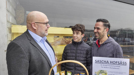 Bürgermeisterwahl in Niefern-Öschelbronn. Bürgermeisterkandidat Sascha Hofsäß an seinem Info-Stand vor dem REWE-Markt.