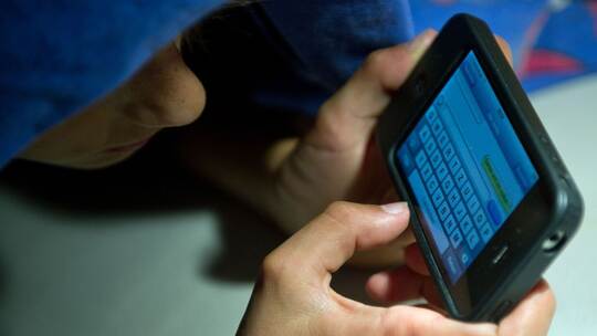 Jugendlicher beim Schreiben einer SMS