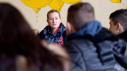 Eine Sozialpädagogin spricht mit Schülern. Sie will ihnen helfen, Probleme zu bewältigen und nicht den Anschluss zu verlieren. F Schulsozialarbeit