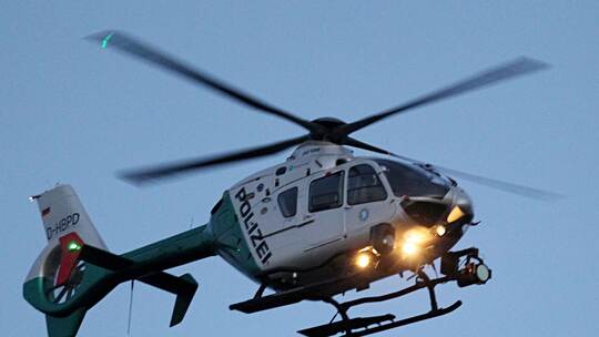 Ein Polizeihubschrauber mit eingeschalteten Scheinwerfern Ein Polizeihubschrauber mit eingeschalteten Scheinwerfern