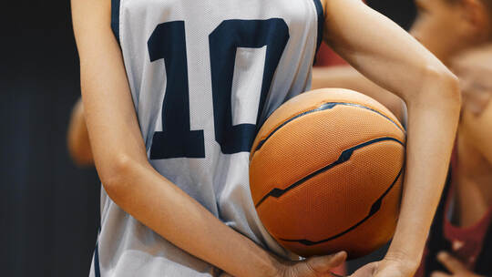 Junior level basketball player holding game ball. Basketball training session for kids