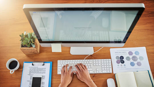 Driving productivity into her workday. High angle shot of an unrecognizable woman working at her desk at home.
