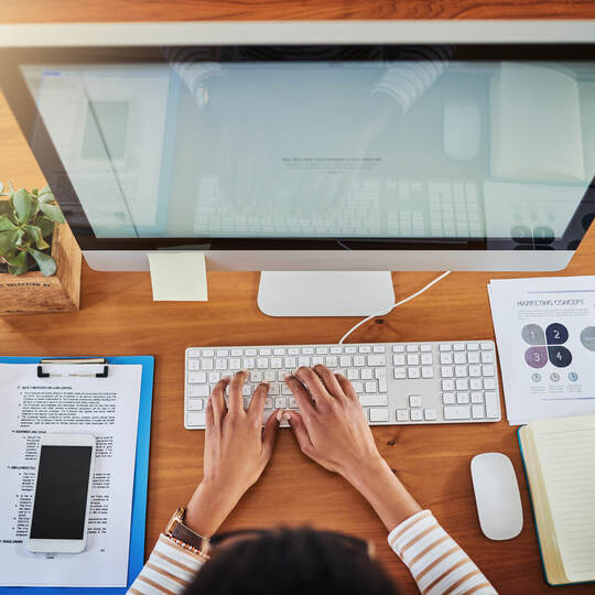Driving productivity into her workday. High angle shot of an unrecognizable woman working at her desk at home.