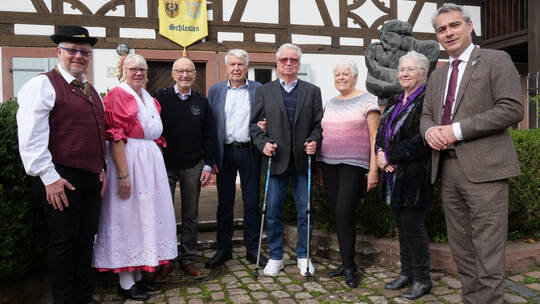 Der Bundesvorsitzende Stephan Rauhut (rechts) blickt mit dem Vorsitzenden der Landsmannschaft Pforzheim (Vierter von links) und