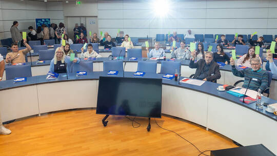 Mit grünen Kärtchen in der Hand zeigt das Plenum der Jugendkonferenz „KlimaTalk“ seine Zustimmung. Foto: Röhr