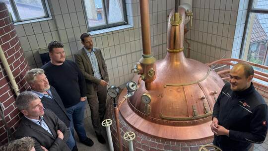 Erklärungen am Braukessel: (von rechts) Leopold Volk, Landrat Bastian Rosenau, Conrad und Robert Volk, Bürgermeister Matthias En